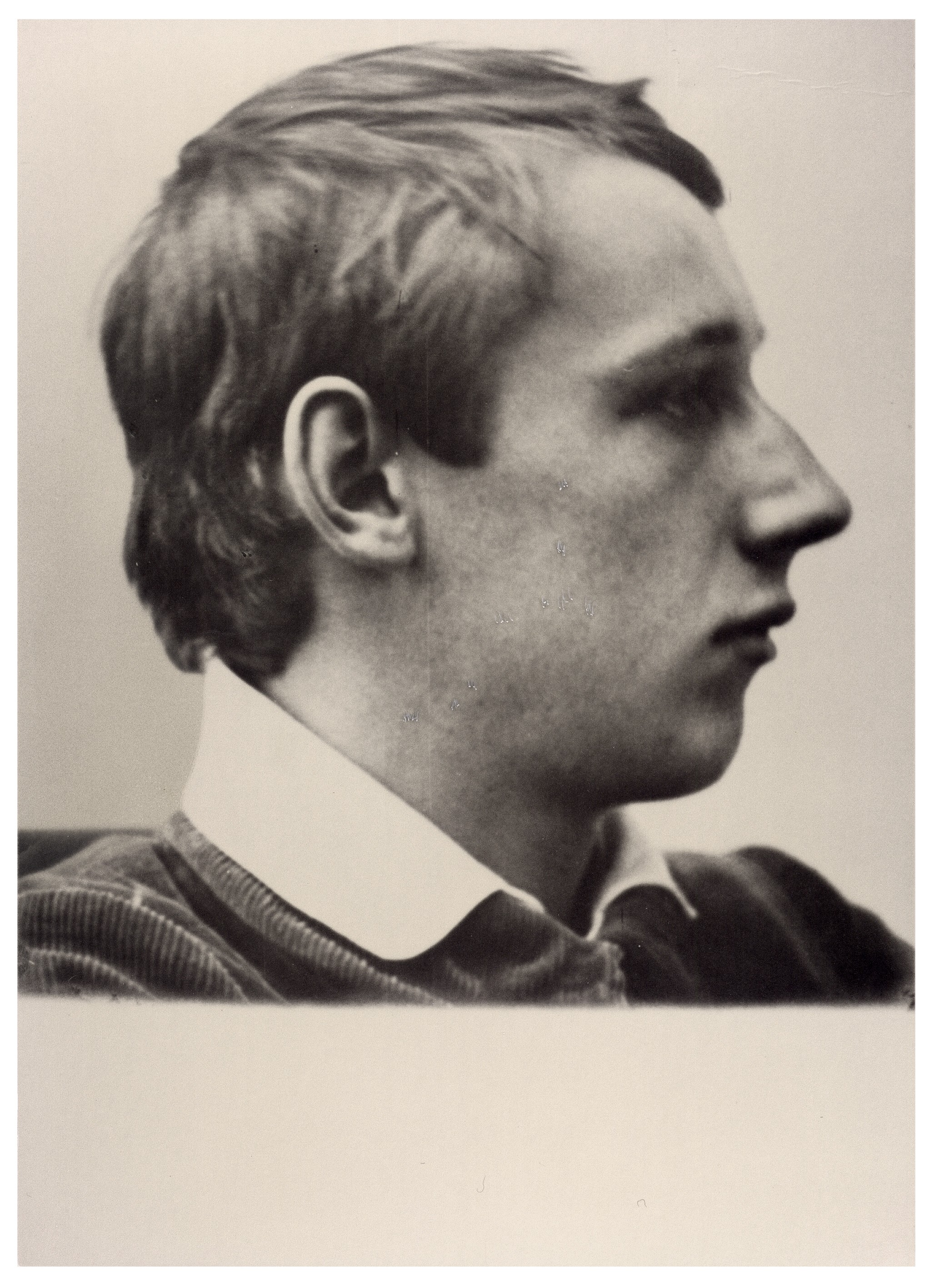The black-and-white photograph, dating from 1913, shows a profile view of Peter Kollwitz (1896–1914) looking to the right. He wears a dark ribbed garment with a light-coloured polo collar and has short, slightly wavy hair.