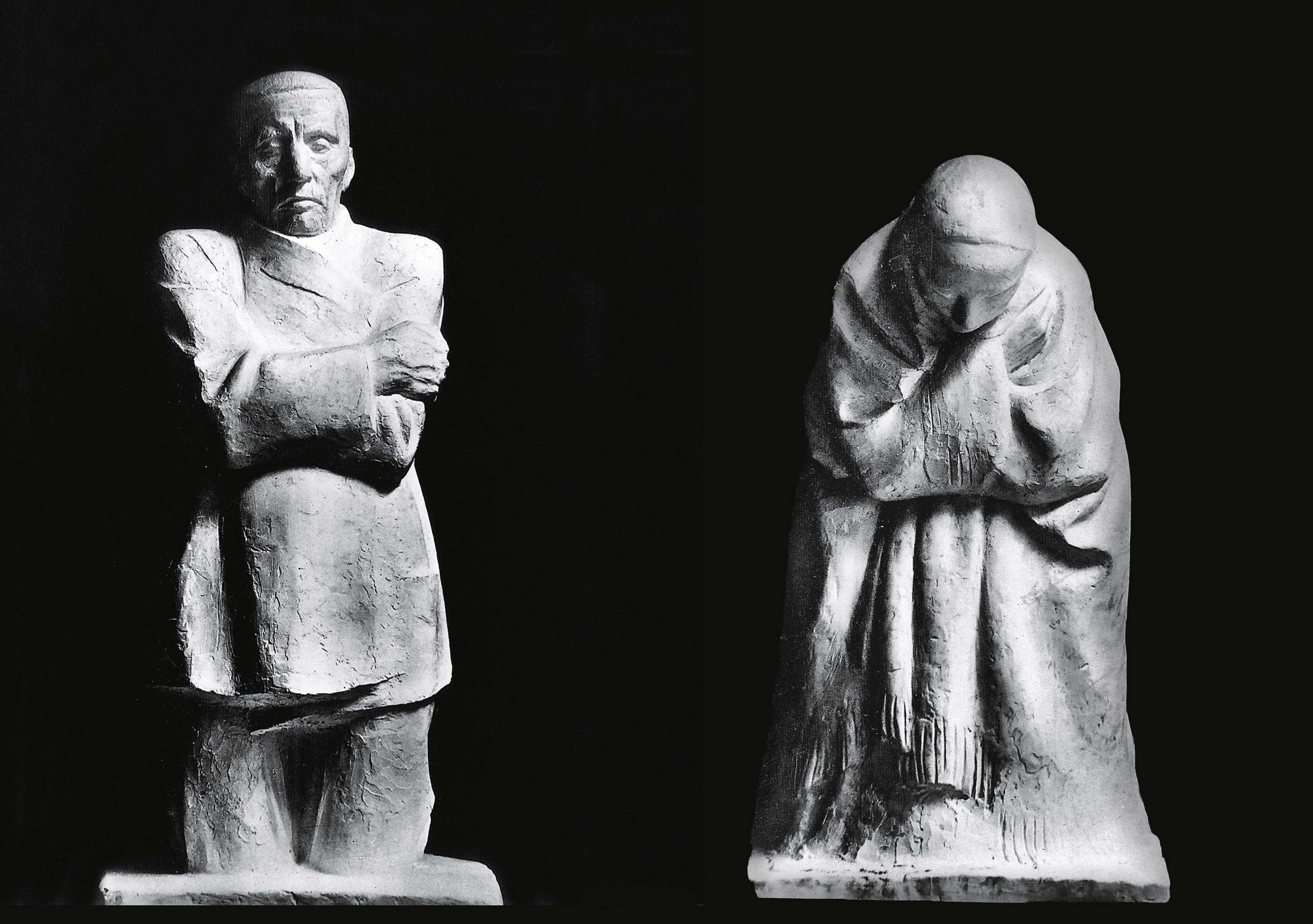 Black-and-white reproduction showing two plaster sculptures by Käthe Kollwitz against a dark background. On the left, The Father stands upright with crossed arms and a tense, rigid posture. On the right, The Mother appears bowed forward, wrapped in draped clothing with her head lowered in grief. The contrasting poses convey mourning, sorrow, and emotional weight.